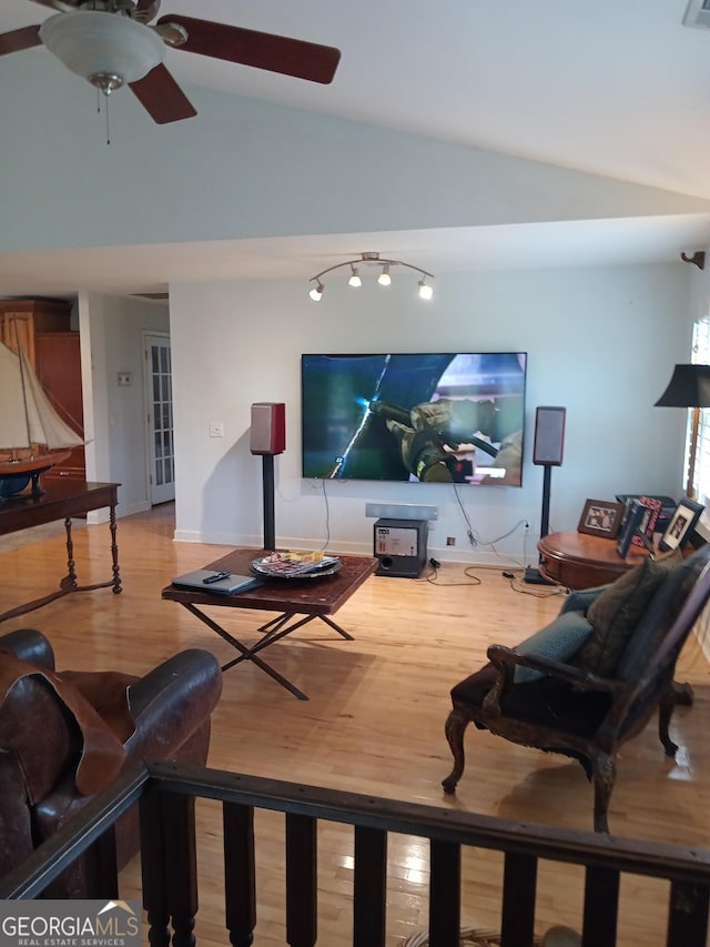 living room featuring hardwood / wood-style floors, vaulted ceiling, and ceiling fan