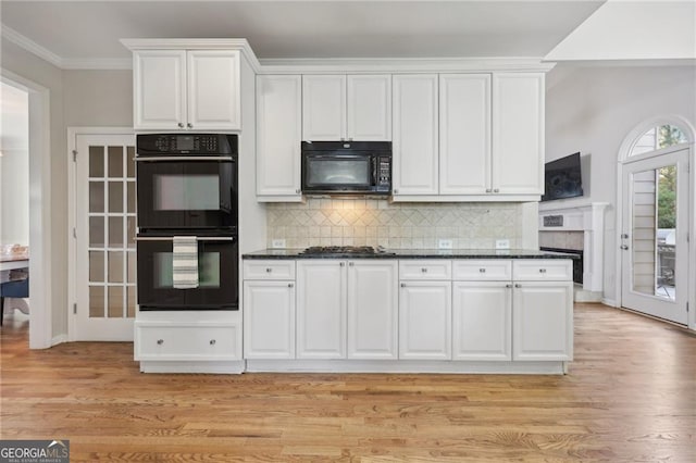 kitchen with black appliances, dark stone countertops, ornamental molding, decorative backsplash, and white cabinets