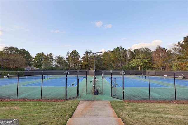 view of tennis court with a lawn