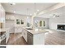 kitchen with decorative light fixtures, a center island, sink, and white cabinets