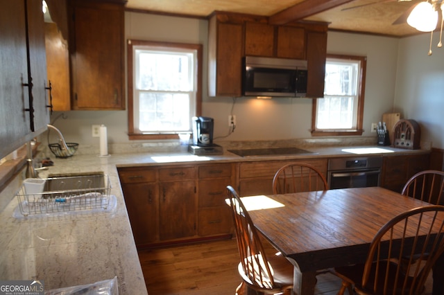 kitchen featuring sink, wood-type flooring, ceiling fan, and appliances with stainless steel finishes