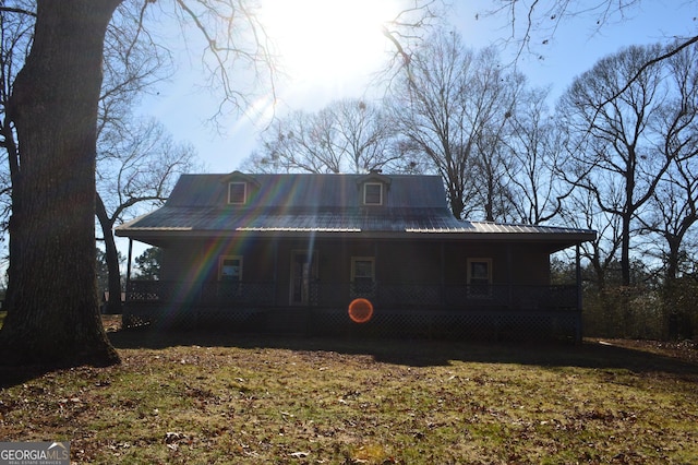 back of house with a porch and a yard