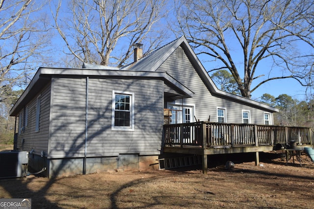 rear view of property with a wooden deck and central AC unit