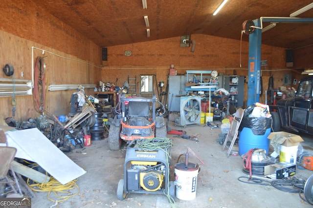 garage featuring a workshop area and wood walls