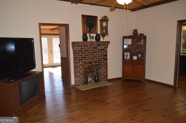 unfurnished living room with beam ceiling, wood ceiling, dark hardwood / wood-style flooring, and a fireplace