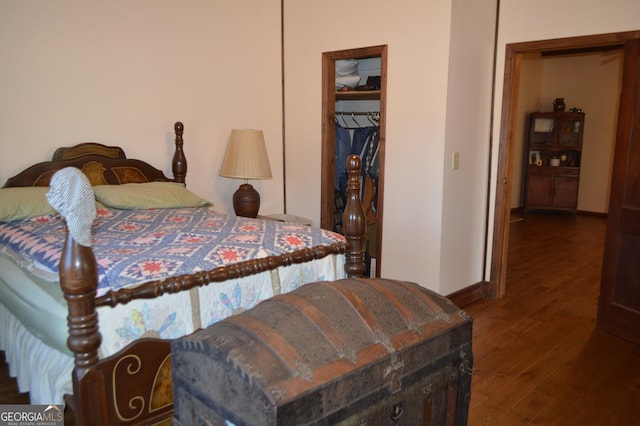 bedroom with dark hardwood / wood-style flooring and a closet