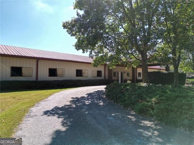 3055 Spring Hill Dr, Monroe, GA 30656 - ranch-style home featuring driveway, metal roof, board and batten siding, and a front yard