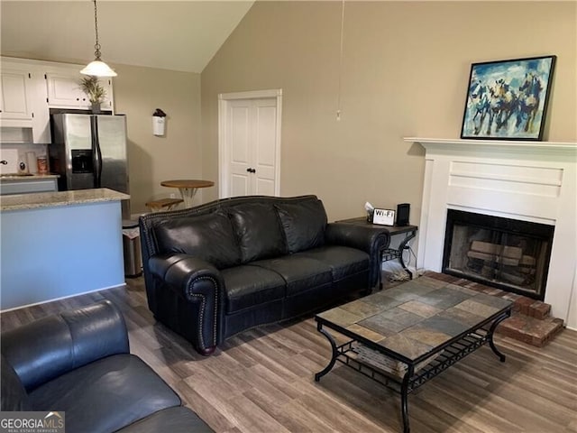 living room featuring sink, hardwood / wood-style floors, and high vaulted ceiling