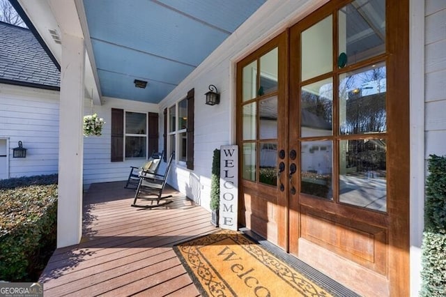 wooden terrace featuring french doors and covered porch