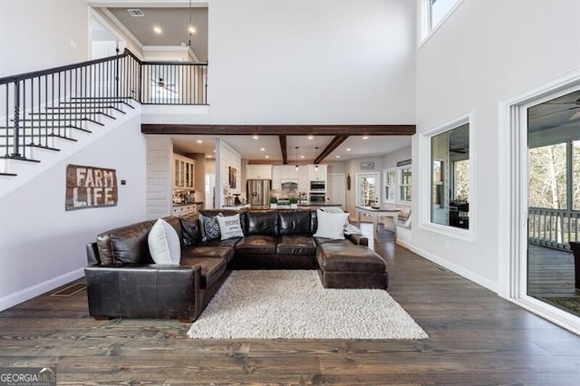 living area with dark wood-style flooring, a high ceiling, stairway, and baseboards