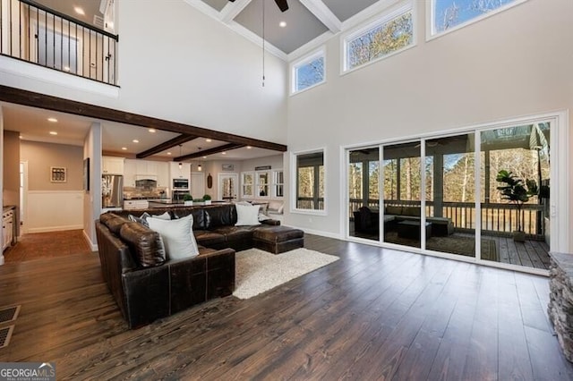 living room featuring dark wood-style floors, beam ceiling, and a ceiling fan