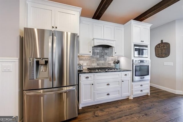 kitchen with dark wood-type flooring, exhaust hood, white cabinetry, appliances with stainless steel finishes, and beamed ceiling