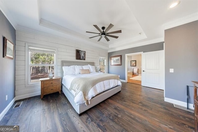 bedroom featuring ornamental molding, a raised ceiling, and dark wood finished floors