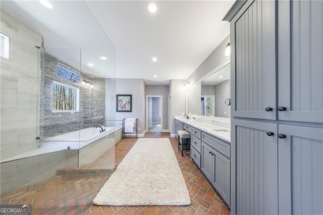 bathroom featuring a shower with door, a garden tub, brick floor, vanity, and recessed lighting