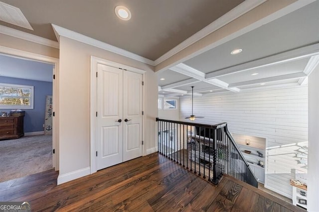 hallway with dark wood-type flooring, ornamental molding, an upstairs landing, beamed ceiling, and baseboards