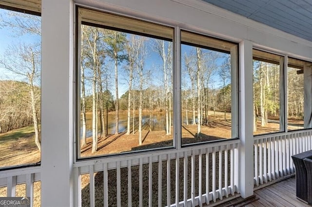 doorway to outside with ornamental molding, a water view, and wood finished floors