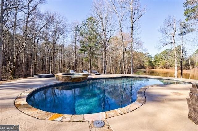 view of pool featuring a pool with connected hot tub and a patio