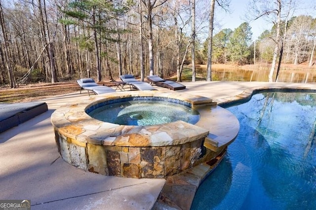 view of swimming pool with a patio area and a pool with connected hot tub