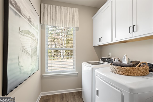 laundry area featuring hardwood / wood-style flooring, cabinets, and washing machine and dryer