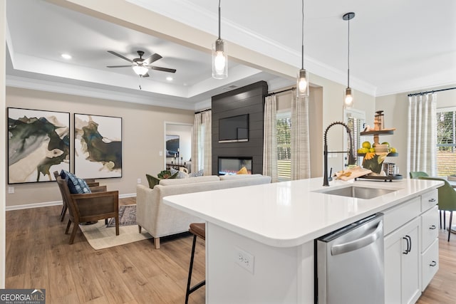 kitchen with sink, white cabinetry, hanging light fixtures, a center island with sink, and stainless steel dishwasher