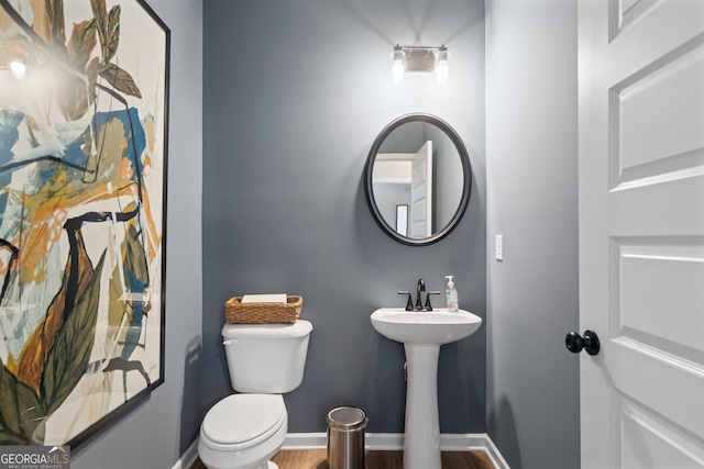 bathroom with hardwood / wood-style flooring and toilet