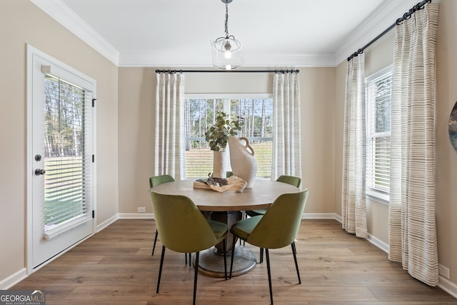 dining area featuring crown molding and light hardwood / wood-style floors