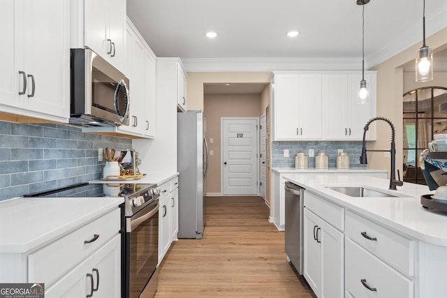 kitchen featuring white cabinetry, appliances with stainless steel finishes, sink, and pendant lighting