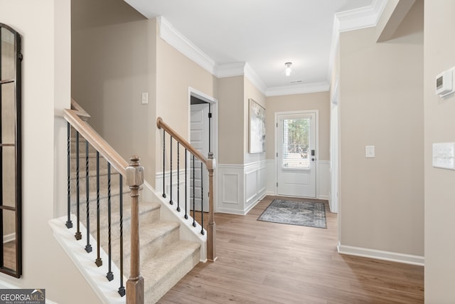 entryway featuring ornamental molding and light hardwood / wood-style floors