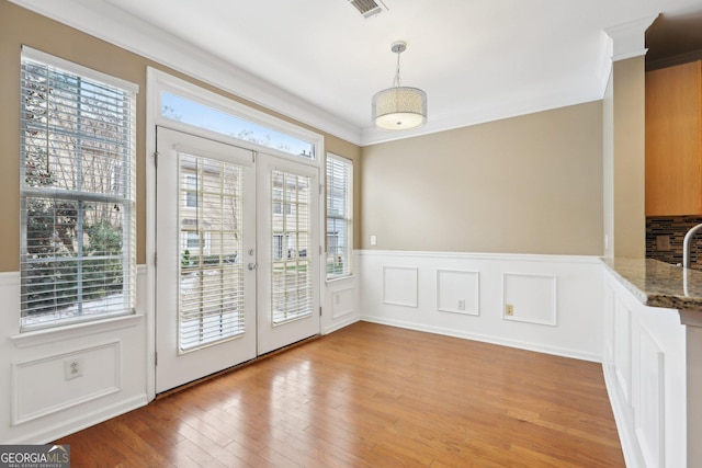 entryway featuring french doors, a healthy amount of sunlight, and crown molding