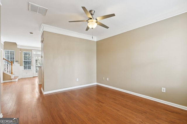 empty room with crown molding, wood-type flooring, and ceiling fan