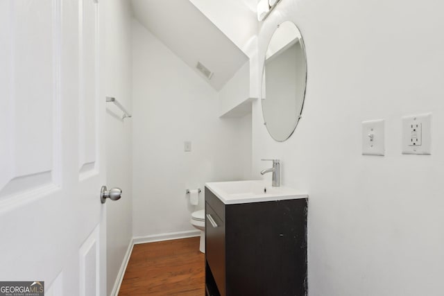 bathroom with vanity, hardwood / wood-style flooring, and toilet