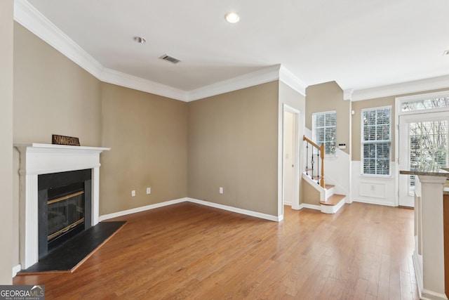 unfurnished living room featuring crown molding and light hardwood / wood-style floors