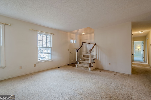 interior space with light carpet and a textured ceiling