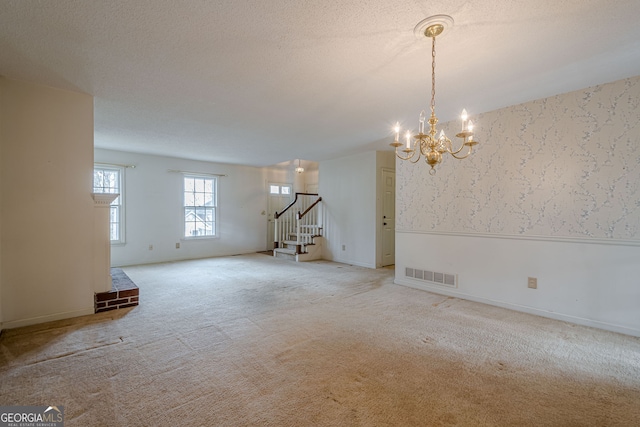 empty room featuring light carpet and a textured ceiling