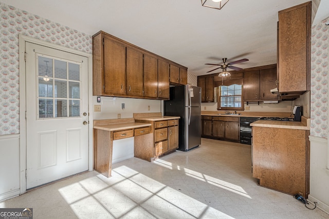 kitchen featuring stainless steel refrigerator, ceiling fan, range, and sink