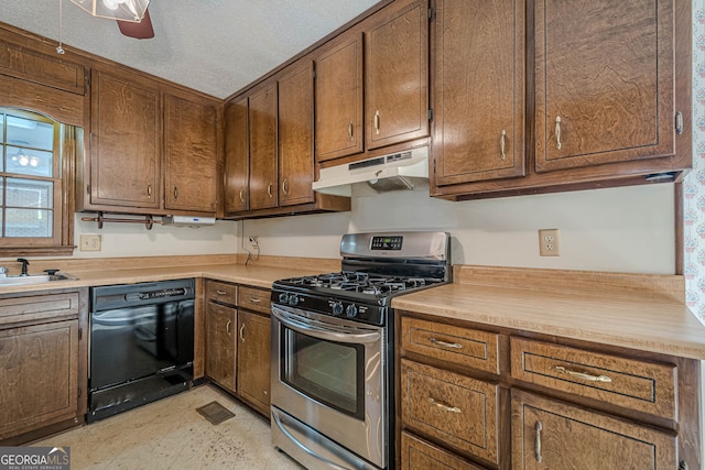 kitchen featuring sink, gas stove, a textured ceiling, black dishwasher, and ceiling fan