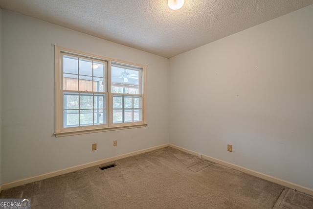 carpeted empty room with a textured ceiling