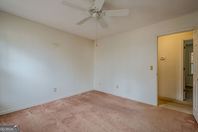 carpeted spare room with ceiling fan and a textured ceiling