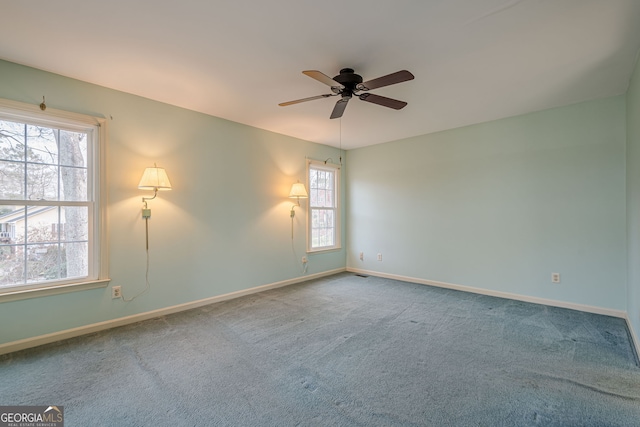 carpeted spare room featuring ceiling fan