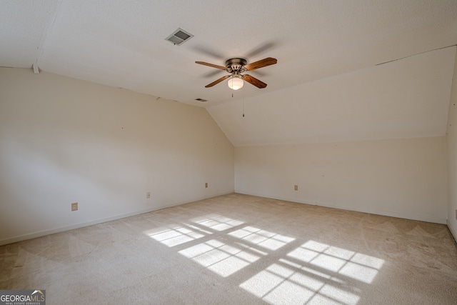 additional living space with ceiling fan, light colored carpet, and lofted ceiling