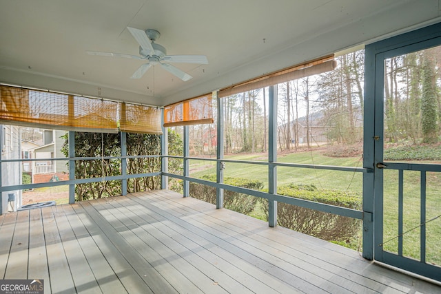 unfurnished sunroom featuring ceiling fan