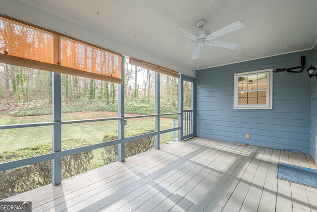 unfurnished sunroom featuring ceiling fan