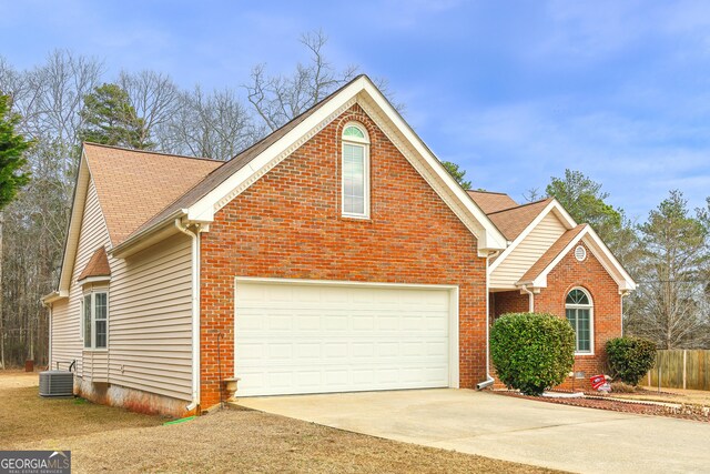 view of property featuring a garage and cooling unit