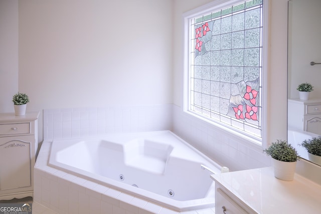 bathroom with vanity and tiled bath