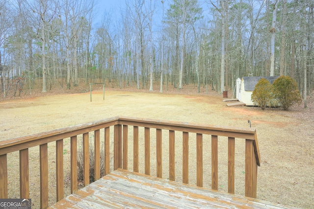 deck featuring a storage shed and a yard