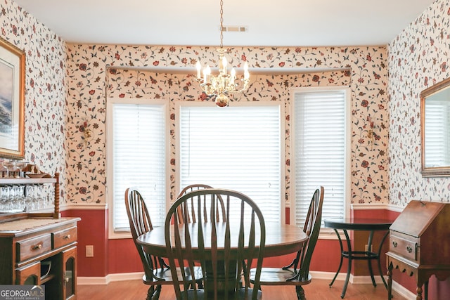 dining area featuring light hardwood / wood-style floors and a notable chandelier