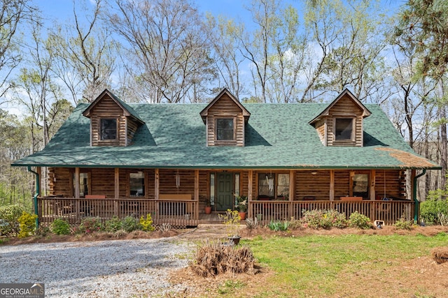 log cabin with a porch and a front lawn