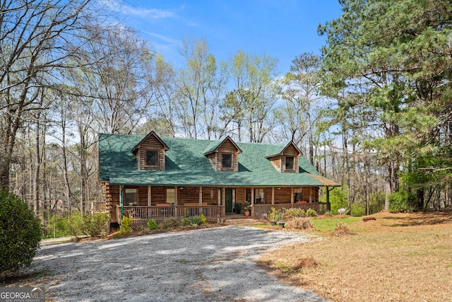 log home featuring a porch and a front lawn