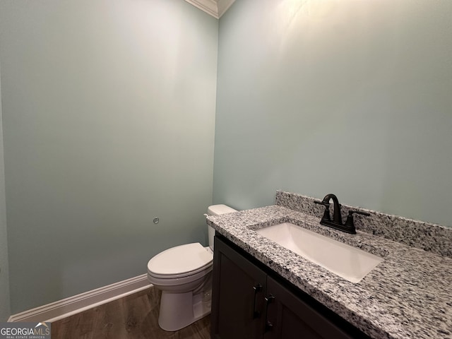 bathroom with hardwood / wood-style flooring, vanity, and toilet