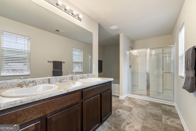 bathroom featuring walk in shower, vanity, and a wealth of natural light